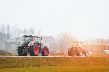 Fototapeta premium Slow-moving green tractor traveling to farming destination