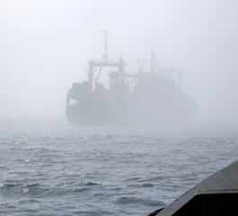 Fishing vessel ship in thick fog on north sea