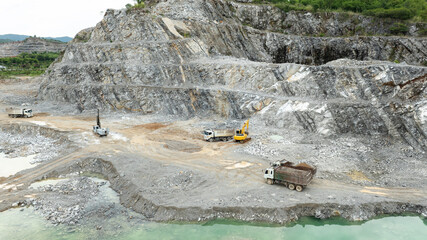 drilling area explosion mountain limestone, small backhoe and truck aerial view.