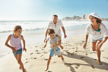 Running, playing and happy family at a beach with fun, bonding and freedom on summer, vacation and holiday. Travel, energy or excited kids with parents at ocean for adventure, journey or race in Bali