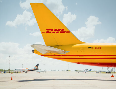tail of DHL cargo aircraft. Side view of the empennage of yellow Boeing 757 (D-ALED) parked on apron on a sunny day. Boryspil, Ukraine - May 22 2015.