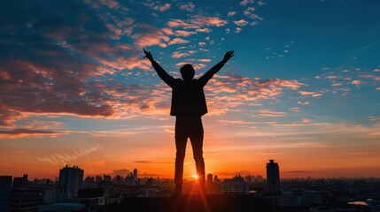 Fototapeta premium A silhouette of a victorious person against a cityscape