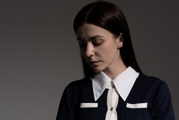 Portrait of attractive caucasian young brunette woman in school uniform in studio. Elegant woman posing. Pretty stylish model. Beauty, Style, Fashion, Luxury