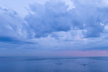 Obraz premium White nights over the Gulf of Finland. Lilac clouds and small boats on the water.