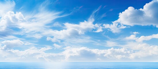 Obraz premium Tranquil scene of a clear blue sky dotted with fluffy clouds on a sunny day, providing a peaceful natural backdrop with room for design in a copy space image.