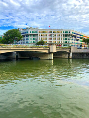 Fototapeta premium Low Angle View of Coleman Bridge Over Singapore River, with the Historic Neoclassical Building of the Old Hill Police Station with its Famous Colorful Windows in the Facade. 