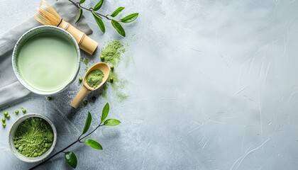 A bowl of green tea with a spoon and some green leaves on a table - Powered by Adobe