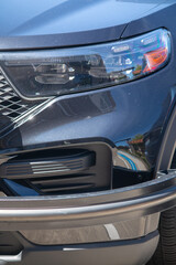 The driver's side headlight of a police cruiser