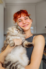 portrait red-haired teenage girl with gray fluffy cat