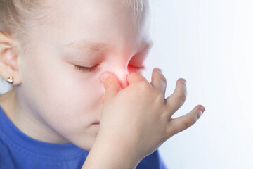 A girl holding her nose has allergic rhinitis with a seasonal disease. Allergens to dust. Nasal...