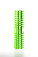 Green massage ribbed roller on a white background, isolate, close-up. The concept of relaxing muscle tension for health and training for back pain.