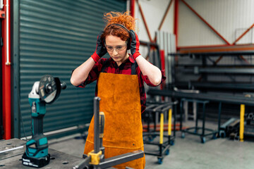 A woman in STEM practices safe work and adjusts protective equipment before starting work