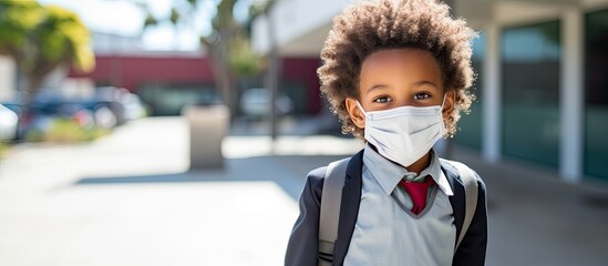 Cheerful student wearing a medical face mask with copy space image on a blackboard backdrop.