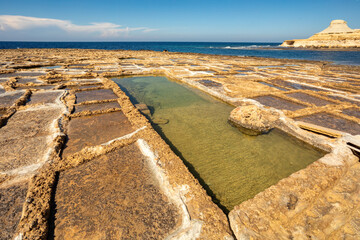 Picturesque scene of Xwejni Bay's traditional salt pans on the beach of island Gozo, Malta.