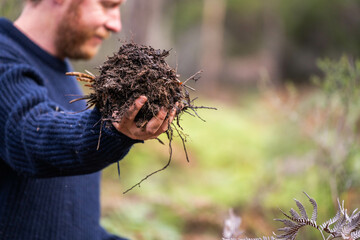 turning a compost pile in a community garden. compost full of microorganisms. sustainable regenerative agriculture