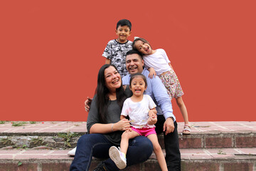 Family of dark-skinned Latino mom, dad, son and daughters looking happy and healthy celebrating their day
