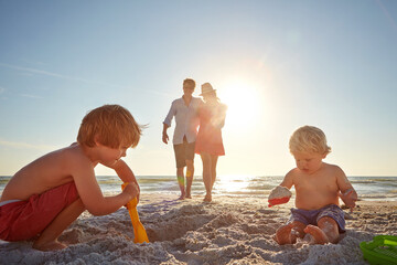 Travel, family and children with sand castle on beach for holiday, summer or vacation together....