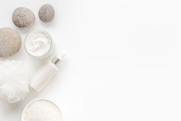 Blank white bottles of skin care cosmetics with roses