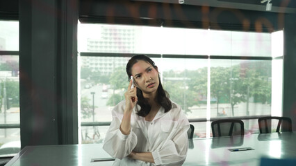 Beautiful female leader thinking about start up project in front of glass board. Smiling young...
