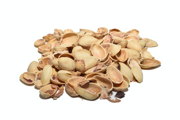 The shells from eaten pistachios lie in a pile on the table.