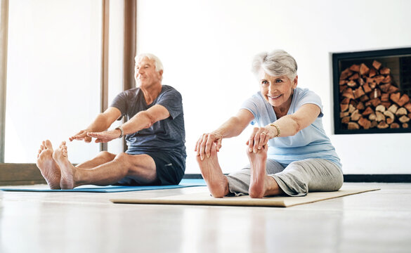 Legs, stretching and senior couple with yoga, exercise and pilates for flexibility in home. Floor, mat and elderly people in retirement with energy balance, fitness or wellness with healthy lifestyle