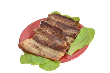 In the picture, thick pieces of bacon are fried on green leaves.