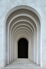 A plain door framed by a series of minimalist arches, each arch slightly larger than the one before, creating a sense of depth and perspective. The background remains solid and neutral