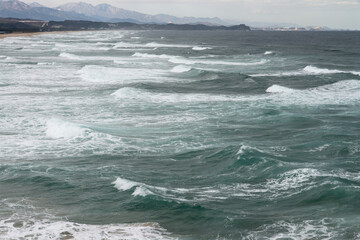 Windy seascape with the rough surf on the beach