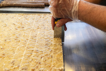 Slicing a dessert made of walnut, semolina and sugar. Walnut paste. Burdur, Turkey.