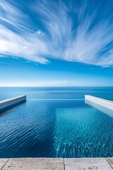 Fototapeta premium Serene infinity pool extends into the ocean under a dynamic cloud streaked sky