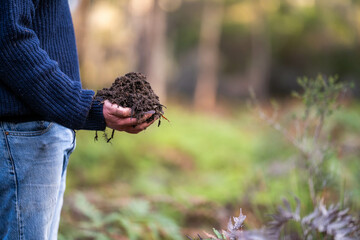 turning a compost pile in a community garden. compost full of microorganisms. sustainable regenerative agriculture