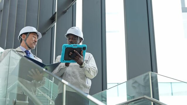 Group of multinational engineers inspecting a building