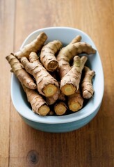 a bowl of ginger root on a wooden table