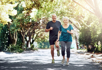 Fototapeta premium Running, outdoor and old couple with fitness, healthy and cardio with challenge, retirement and wellness. Park, elderly man and mature woman with training, exercise and hobby with sunshine and nature