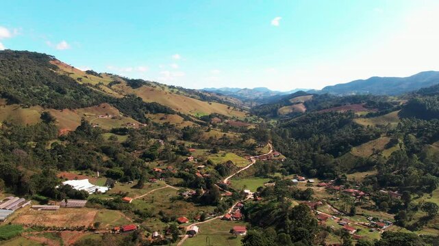 Aerial drone landscape view of neighbourhood location of Delfim Moreira in valley rural farming town suburbs with mountain range forest Minas Gerais Brazil