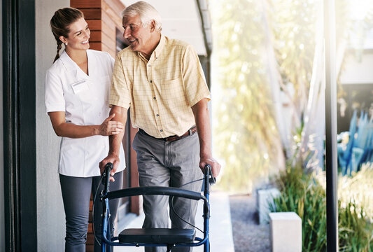 Senior, man and nurse outside with walker, movement and wellness care with healthcare employee in nursing home. Rehabilitation, walking and support with caretaker, physical therapy and happy people
