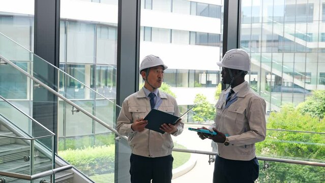 建物の中で会話する多国籍エンジニアのグループ