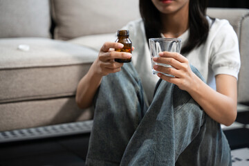 woman holding bottle with pills on hand going to take medicaments prescribed by his physician