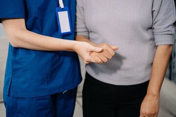 Female hands touching senior male hand Helping hands take care of the elderly concept in hospital