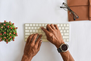 Asian man hand typing on keyboard flat lay or top down view from above