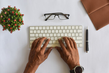 Asian man hand typing on keyboard flat lay or top down view from above