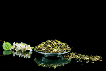 Green tea with jasmine close-up on black background.