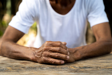 Close up of elderly oldman hands on wooden table.