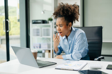 Woman feeling migraine head strain.Overworked businesswoman financier while working on laptop and tablet