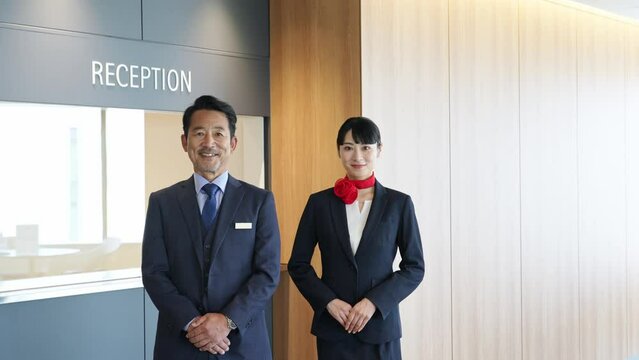 お辞儀するホテルフロントスタッフ
