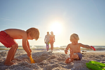 Summer, family and children with sand castle on beach for holiday, travel or vacation together....