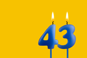 Blue candle number 43 - Birthday on yellow background
