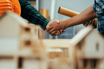 Obraz premium Engineering people and contractor wearing safety helmet on construction site holding blueprint in his hand.