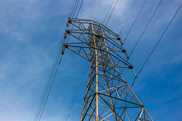 high voltage pylon against blue sky,  Sute tower electric high voltage blue sky tower sutet indonesia, Transmission tower or power line on a sunny day. These are scattered throughout in indonesia