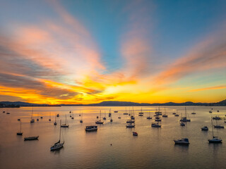 Naklejka premium Aerial sunrise waterscape with boats and high cloud